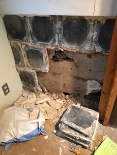 Due to the damage, the tiles came off quite easily for the most part. They were originally set with a goodly amount of a large-ish aggregate lime-sand plaster.